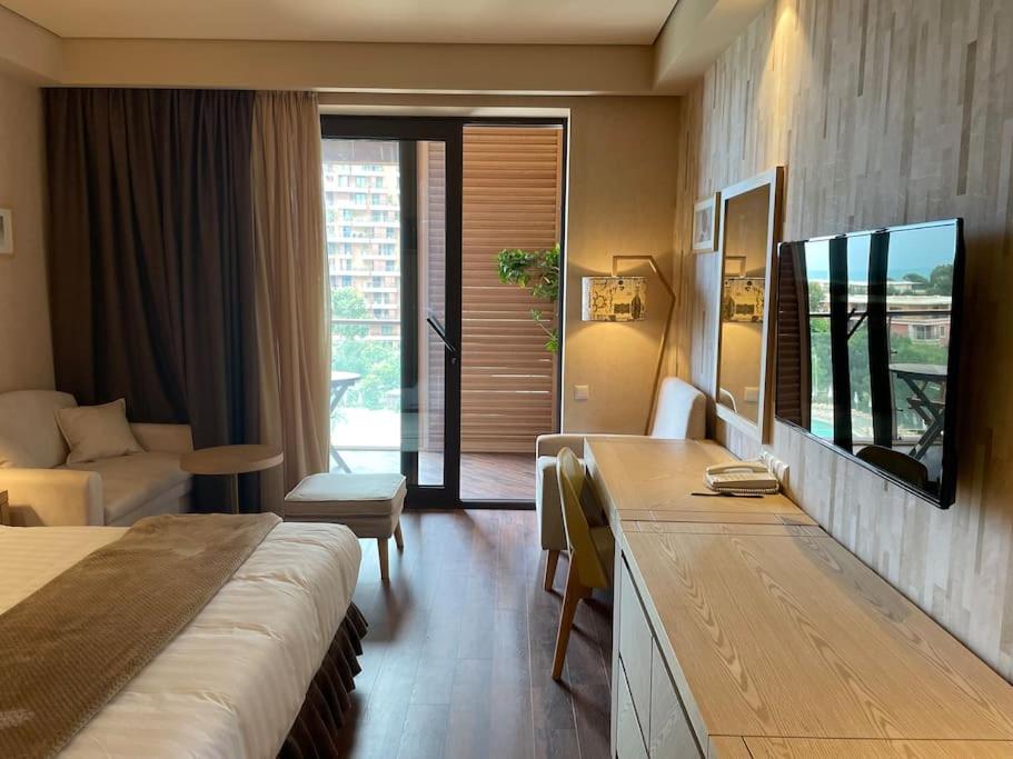 um quarto de hotel com uma cama e uma sala de estar em Dreamland Oasis Apartment 614 em Chakvi