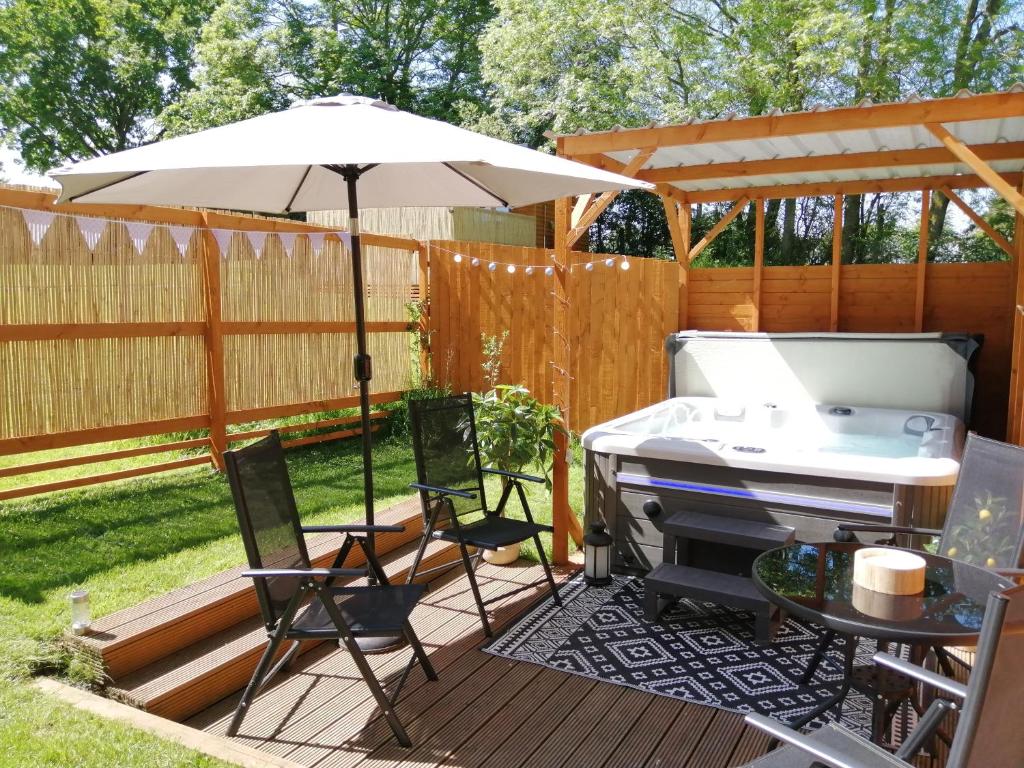 a patio with an umbrella and a grill at Lake District and Eden Valley Thornhill Lodge in Long Marton