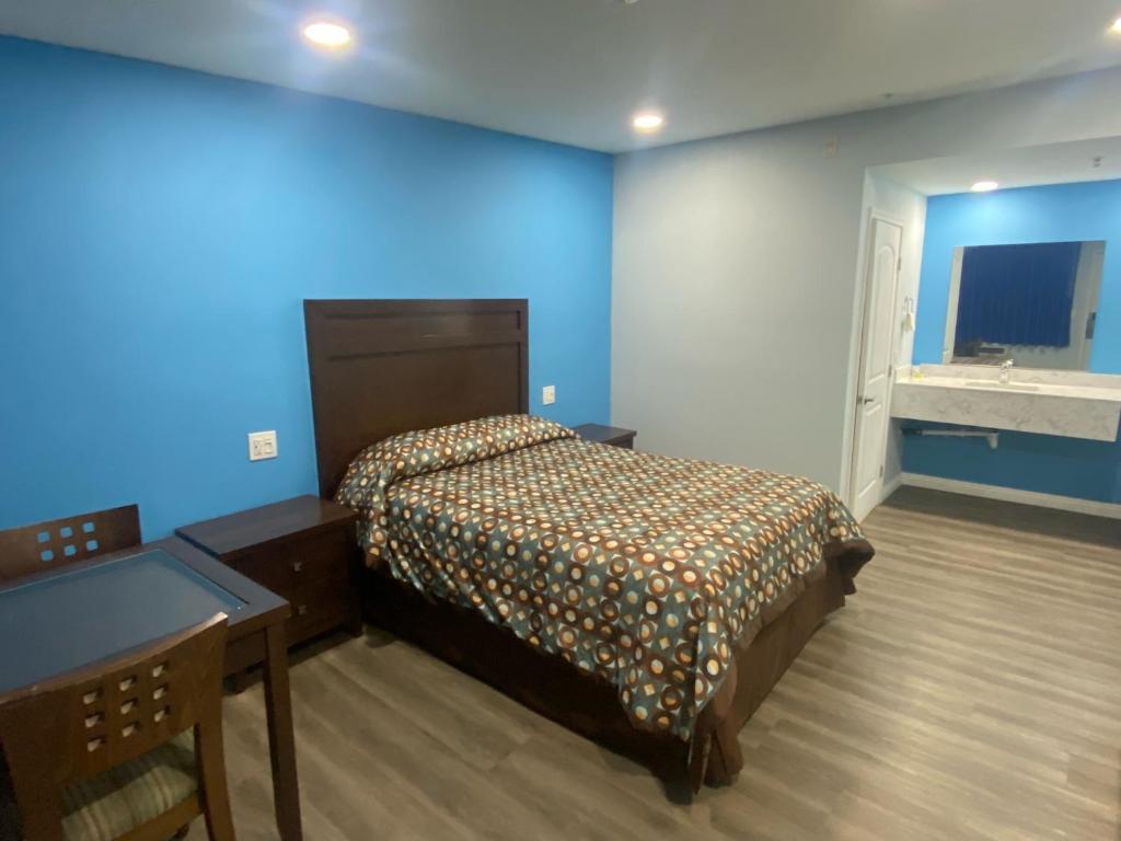 a bedroom with a bed and a desk in it at Star Inn Motel in Costa Mesa