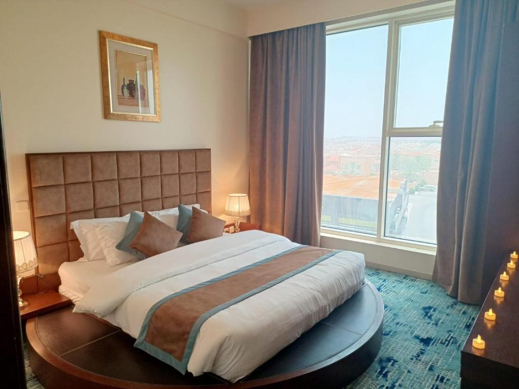 una camera con un grande letto e una grande finestra di راحة للأجنحة الفندقية Comfort hotel suites a Hail