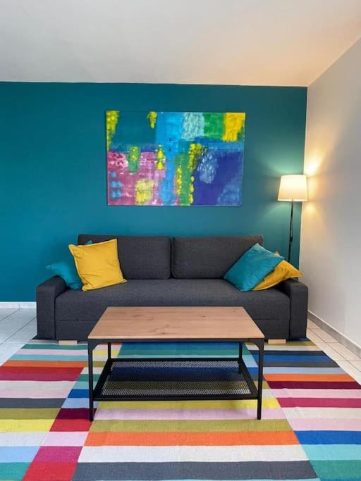 sala de estar con sofá y alfombra colorida en Maisonette parking privé gratuit en Doué-la-Fontaine