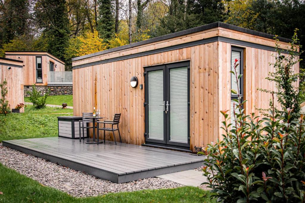Winster的住宿－Comfy Lake District Cabins - Winster, Bowness-on-Windermere，小木屋,在院子里配有桌子和椅子