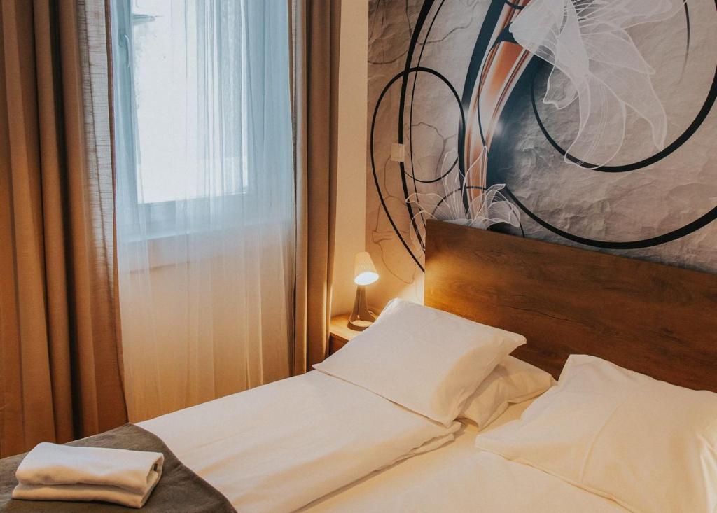 un letto in una camera da letto con un dipinto sul muro di Apartment Latte a Budapest