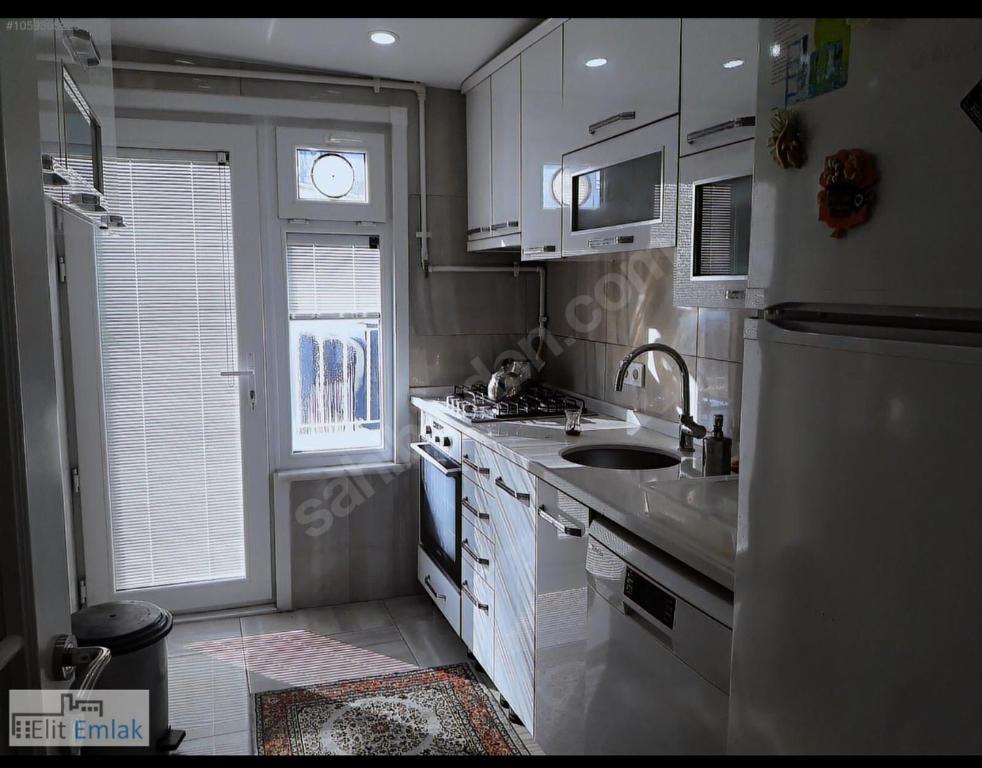 uma cozinha com armários brancos, um lavatório e uma janela em Şişli merkezde Cevahir’e yakın em Istambul