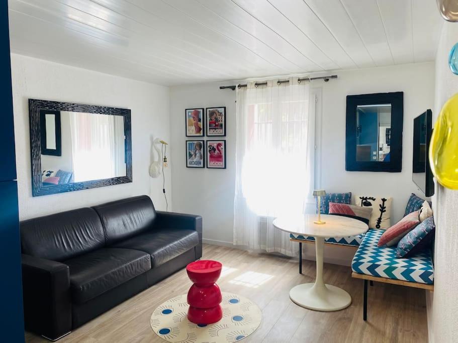- un salon avec un canapé noir et une table dans l'établissement Studio de 21m2 au moulleau à 20 m de la plage, à Arcachon