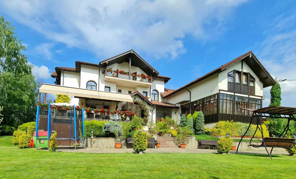 una casa con un columpio en un patio en Casa Domneasca, en Curtea de Argeş