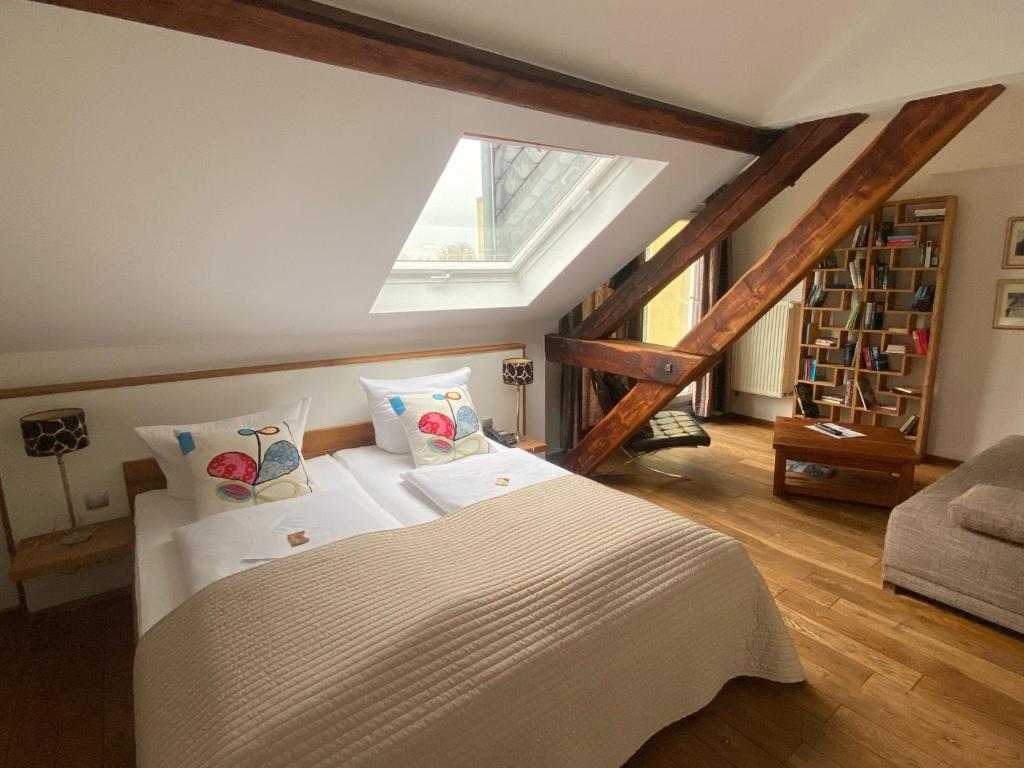 a bedroom with a white bed in a attic at Boutique-garni Hotel Papillon in Kempen