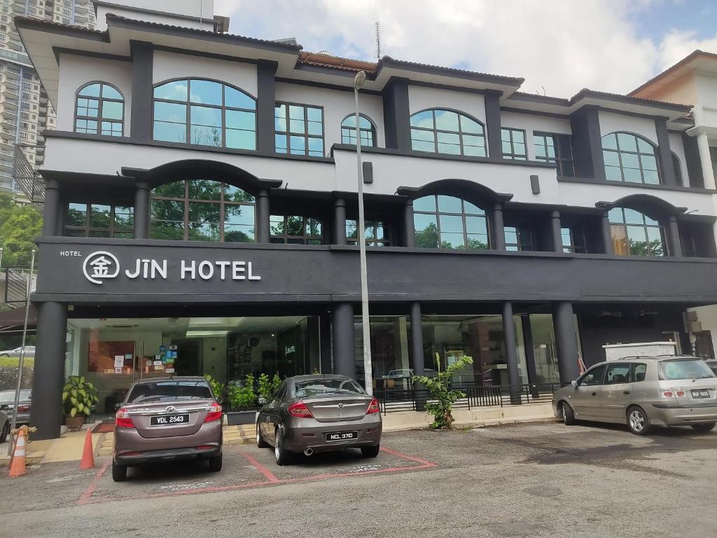 un edificio con coches estacionados frente a él en Jin Hotel, en Puchong
