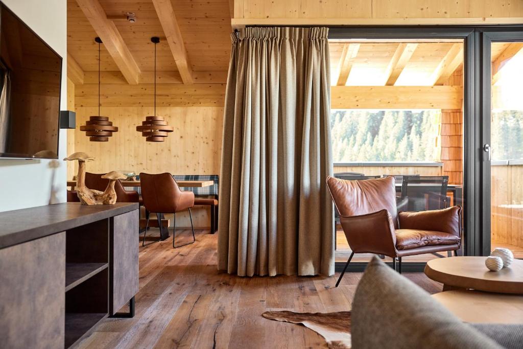 salon z drewnianymi ścianami i dużym oknem w obiekcie Alm-Lodges Montafon by Pferd auf Wolke w mieście Gargellen