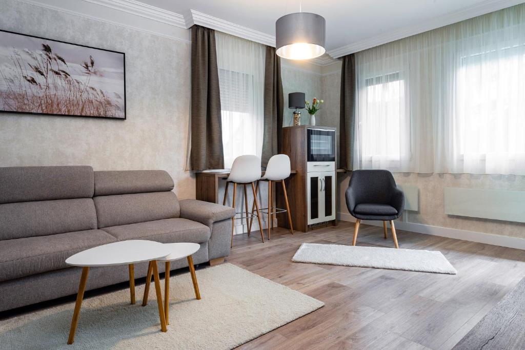 un salon avec un canapé, une table et des chaises dans l'établissement Apartman Nobilis, à Hévíz