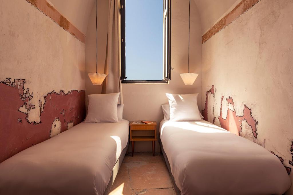 Posteľ alebo postele v izbe v ubytovaní Hôtel La Prison