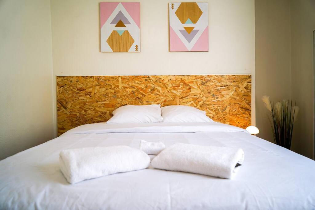 a white bed with two pillows on top of it at Le Tout Doux・Moderne・Calme ・WIFI ・Proche gare in Châteauroux