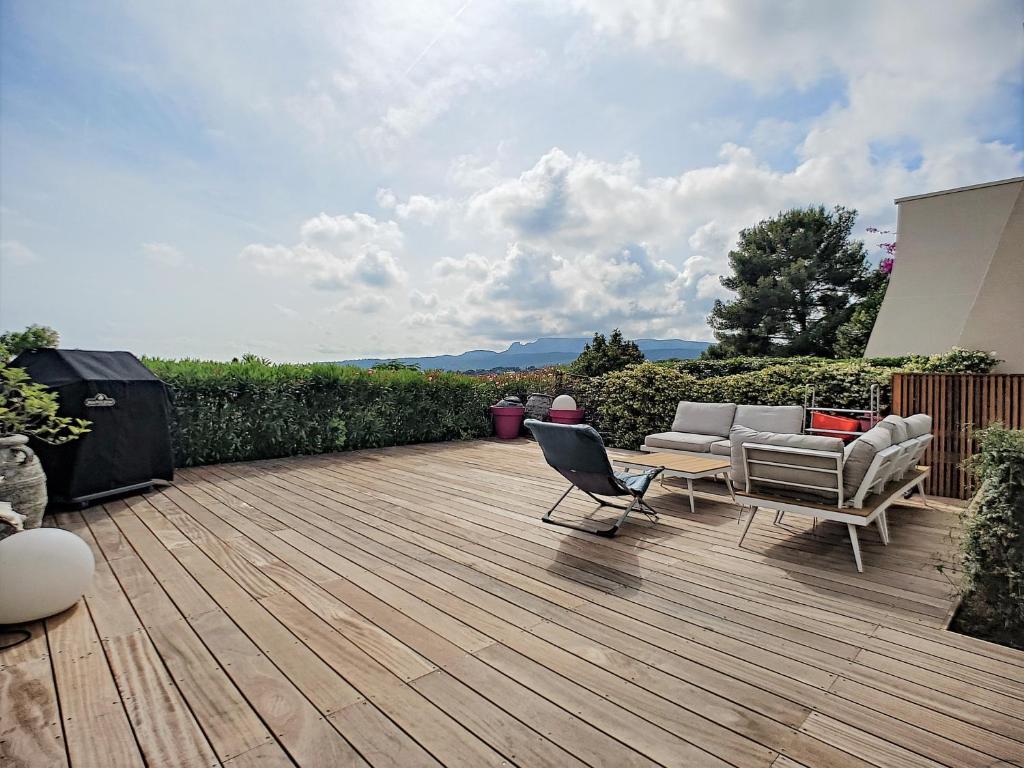une terrasse en bois avec deux chaises et un canapé. dans l'établissement Le Grand Large, face à vous, à Cassis