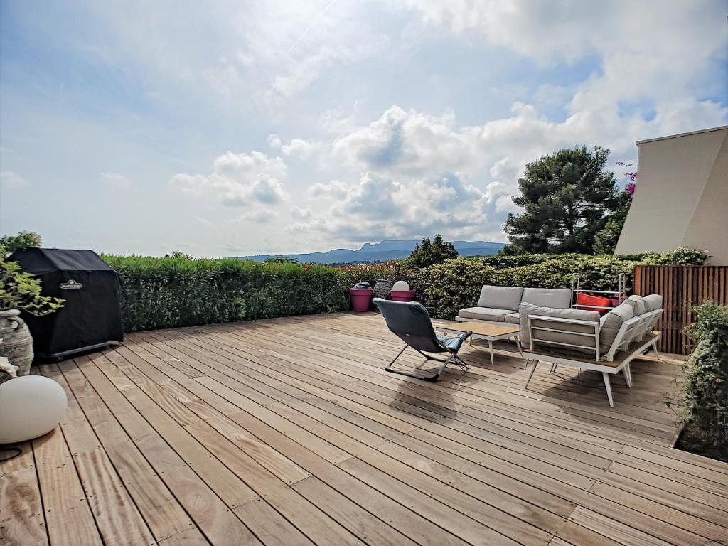 a wooden deck with two chairs and a couch on it at Le Grand Large, face à vous in Cassis