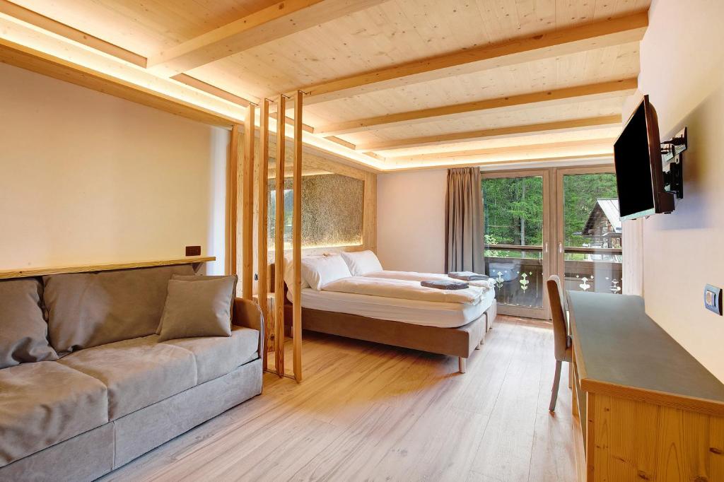una camera con divano e un letto in una stanza di Agriturismo Bosco d'oro 4 a Livigno