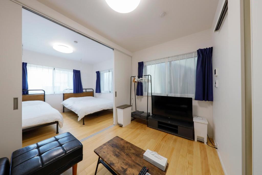 a living room with a couch and a bed and a tv at Setagaya House by Tranova in Tokyo