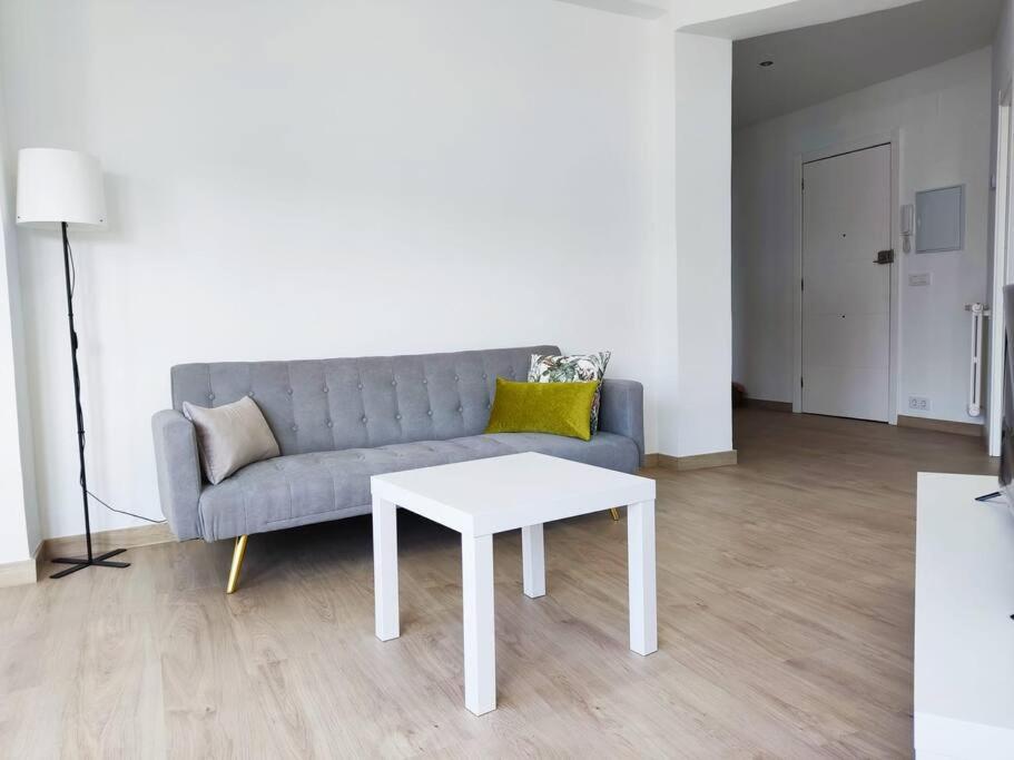 uma sala de estar com um sofá e uma mesa em Mariña Home em Ourense