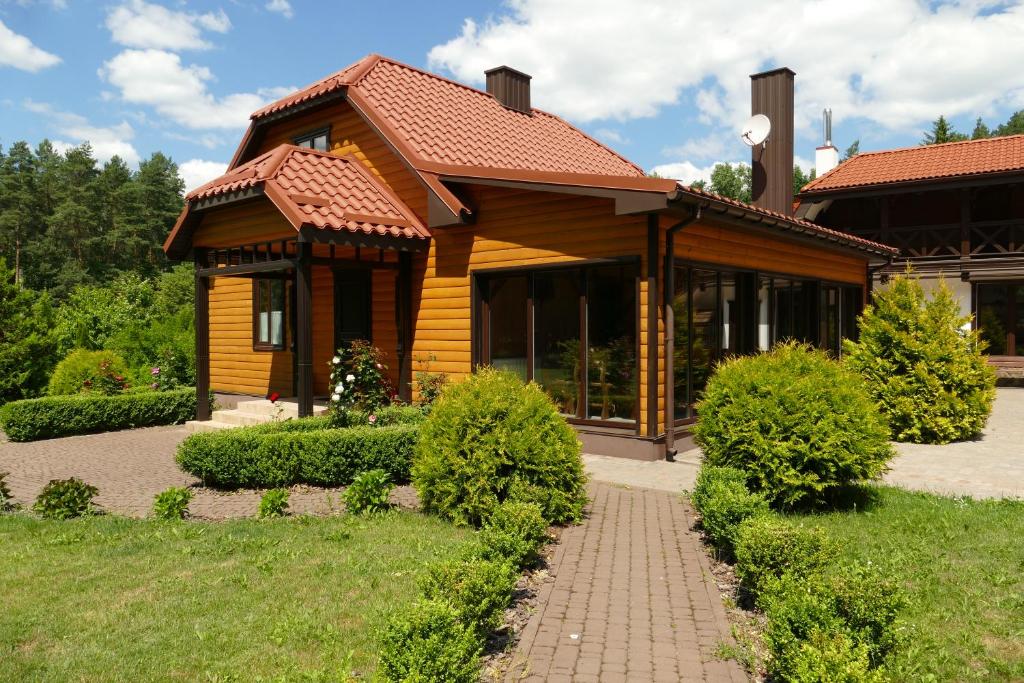uma casa de madeira com um caminho à sua frente em База відпочинку Гаївка котедж em Klevanʼ