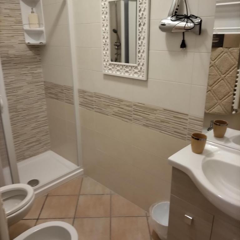 a bathroom with a toilet and a sink and a mirror at B&B VILLA RITA in Silvi Marina