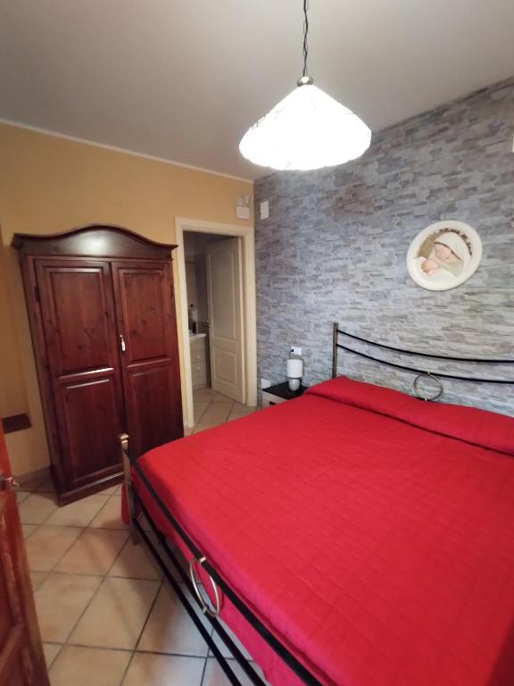 a bedroom with a red bed and a brick wall at B&B VILLA RITA in Silvi Marina