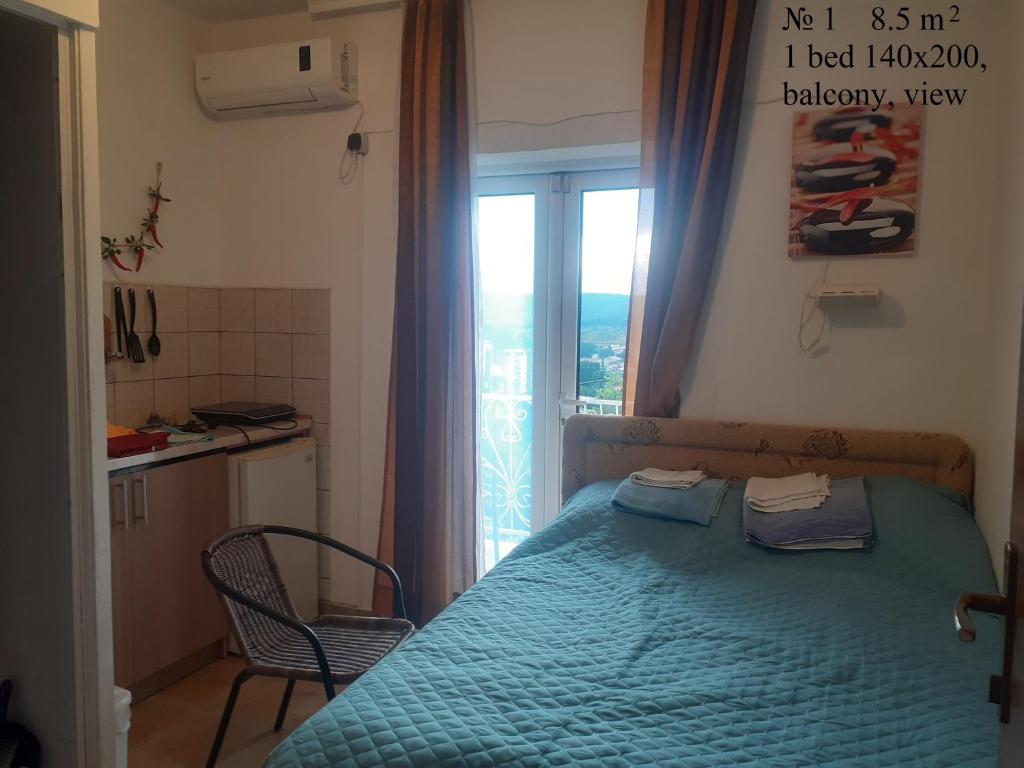 - une chambre avec un lit bleu et une fenêtre dans l'établissement OLGA apartmani, à Sutomore