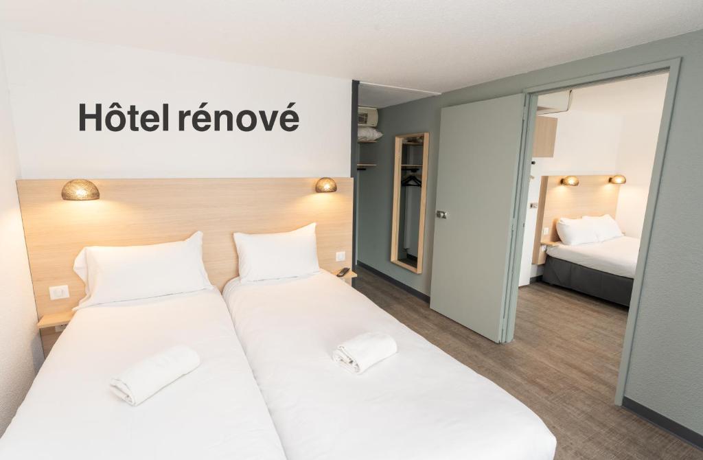 two beds in a hotel room with a hotel remove sign at Hotel Inn Design La Rochelle in La Rochelle