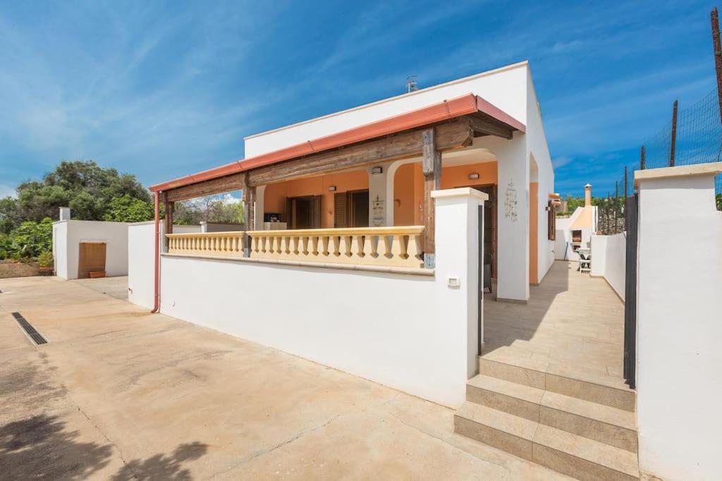 un edificio bianco con portico e balcone di Salentoandmore - Anna Rita Guest House a Marina di Leuca