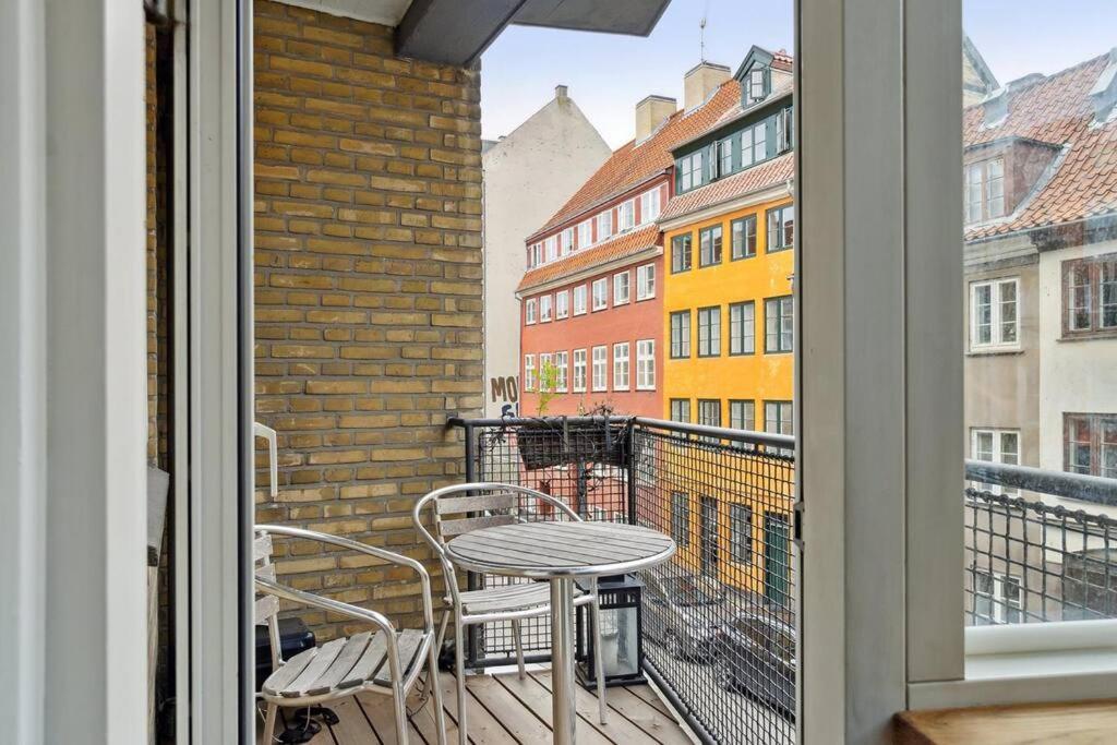 Great central apartment walking distance to metro في كوبنهاغن: شرفة مع طاولة وكراسي ونافذة