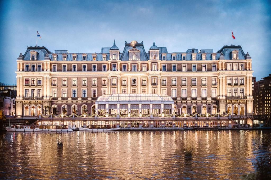 a large building on the water in front at InterContinental Amstel Amsterdam by IHG in Amsterdam