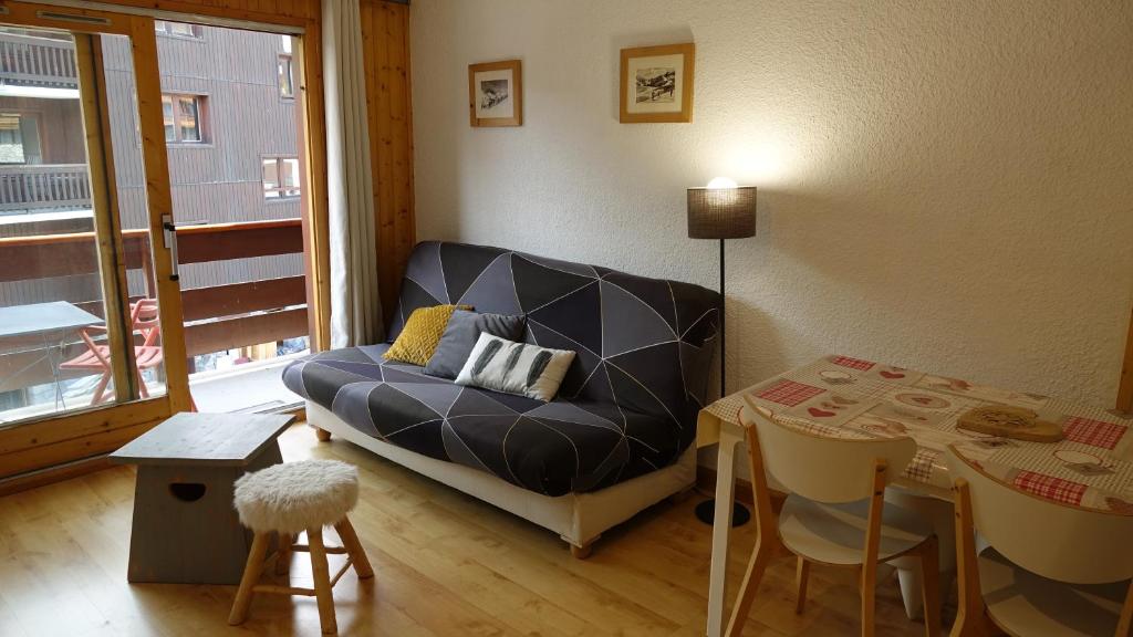uma sala de estar com um sofá e uma mesa em Résidence Alpinéa Mottaret, 2 à 4 pers em Méribel