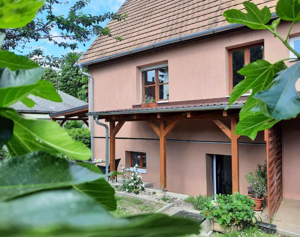 uma casa cor-de-rosa com um telhado castanho em Apartments in Siofok/Balaton 36443 em Siófok