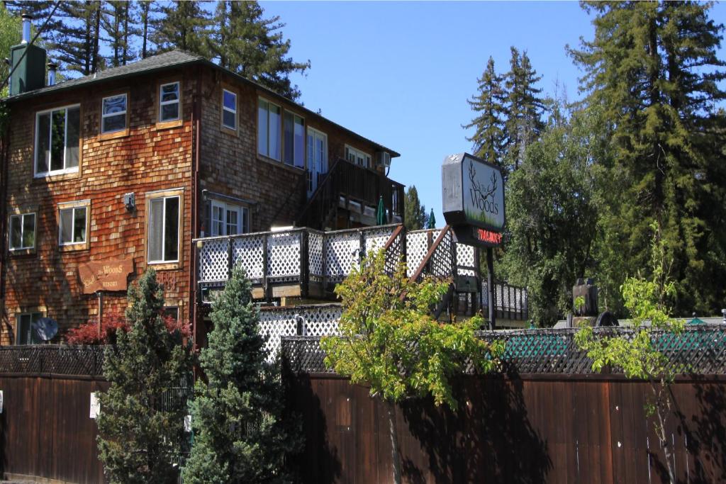 a building with a clock in front of a fence at The Woods Hotel - Gay LGBTQ Cabins in Guerneville