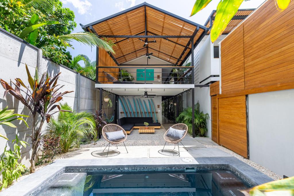 an external view of a house with a swimming pool and two chairs at Ventura Santa Teresa in Santa Teresa Beach