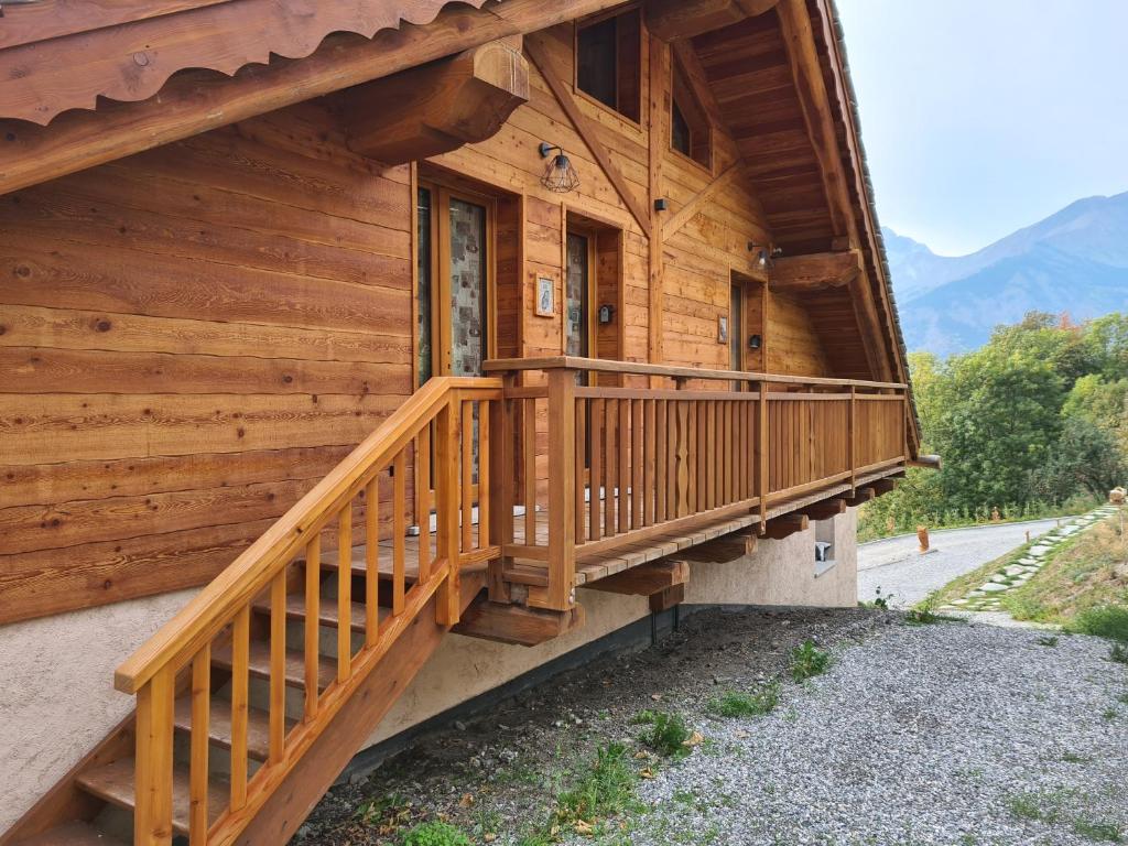 ein Holzhaus mit einer Holztreppe an der Seite in der Unterkunft La Maison. Il Nido dell'Aquila in Bardonecchia