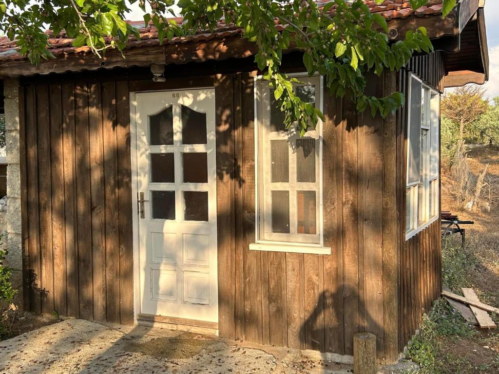 a wooden shed with a door and two windows at sweet horses HH4 in Didim