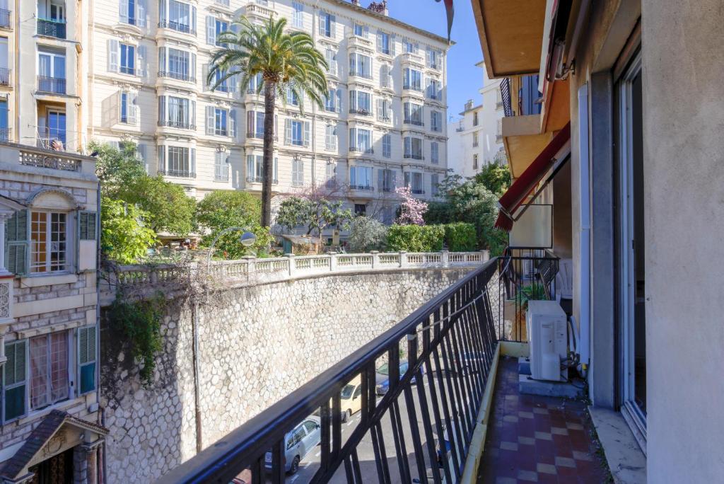 un balcon d'un immeuble avec un palmier et des bâtiments dans l'établissement 26 nice , La Riviera, à Nice
