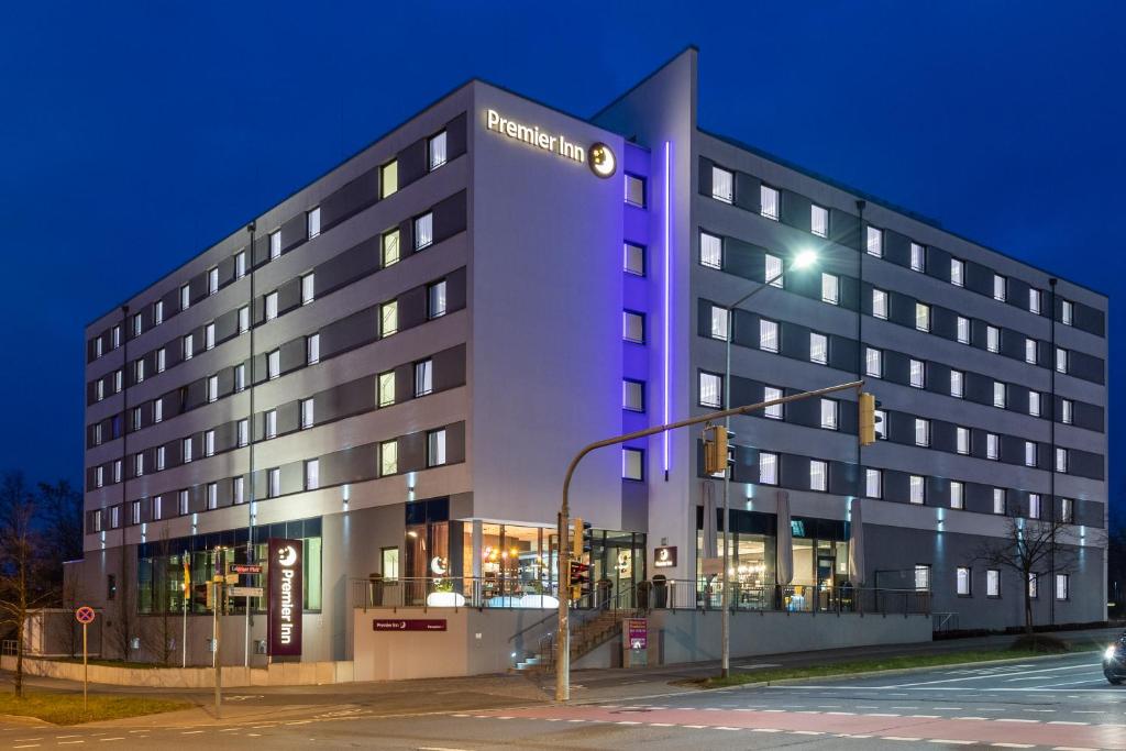 Premier Inn Nürnberg City Nordost في نورنبرغ: مبنى الفندق مع ضوء أرجواني من الأمام