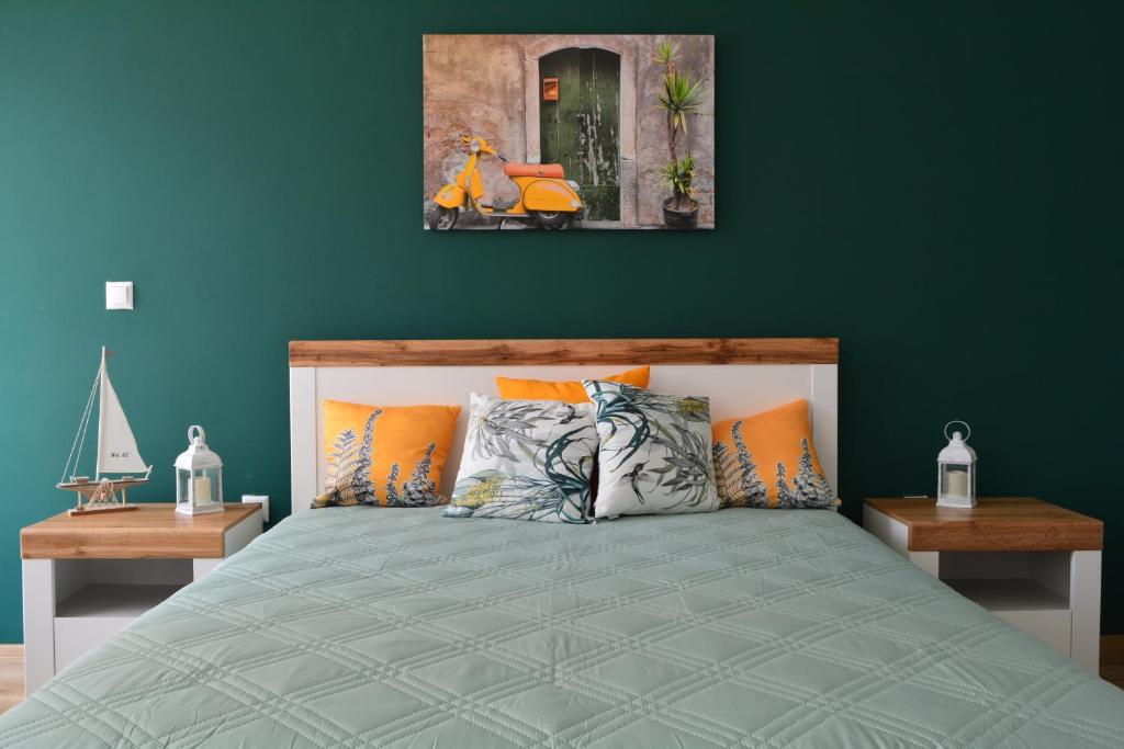 a bedroom with a bed with a green wall at City Center Apartment in Burgas