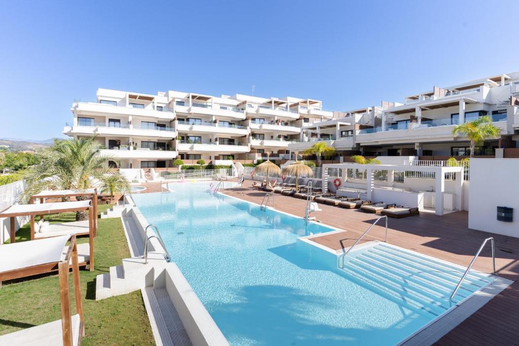 a large swimming pool in front of a building at Jardinana - apartment with two bedrooms close to beach and town center in La Cala de Mijas