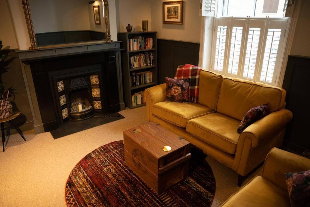 a living room with a couch and a fireplace at Cosy Village House in Waddington