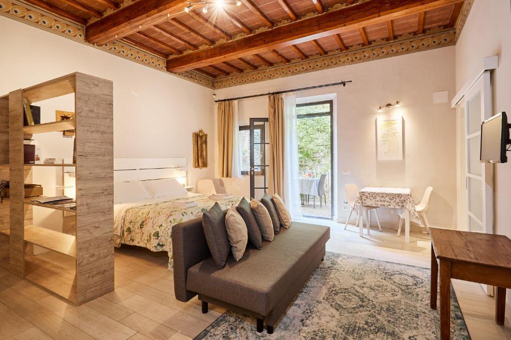 a bedroom with a bed and a couch and a table at Residenza Stuart - La Casa Nido Nest House - Dimora storica in Montepulciano