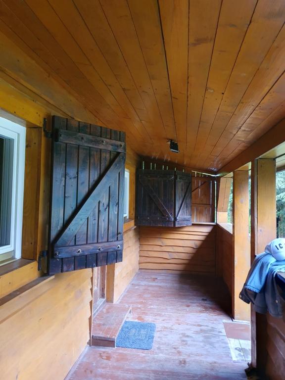an enclosed porch with wooden walls and wooden doors at Malinowe Wzgórze całoroczny domek 30 km od Rzeszowa in Brzeżanka