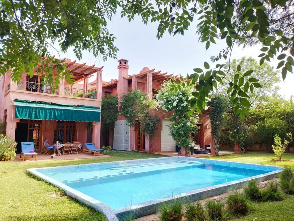 a house with a swimming pool in the yard at Villa Apricot - Golf Amelkis in Marrakech