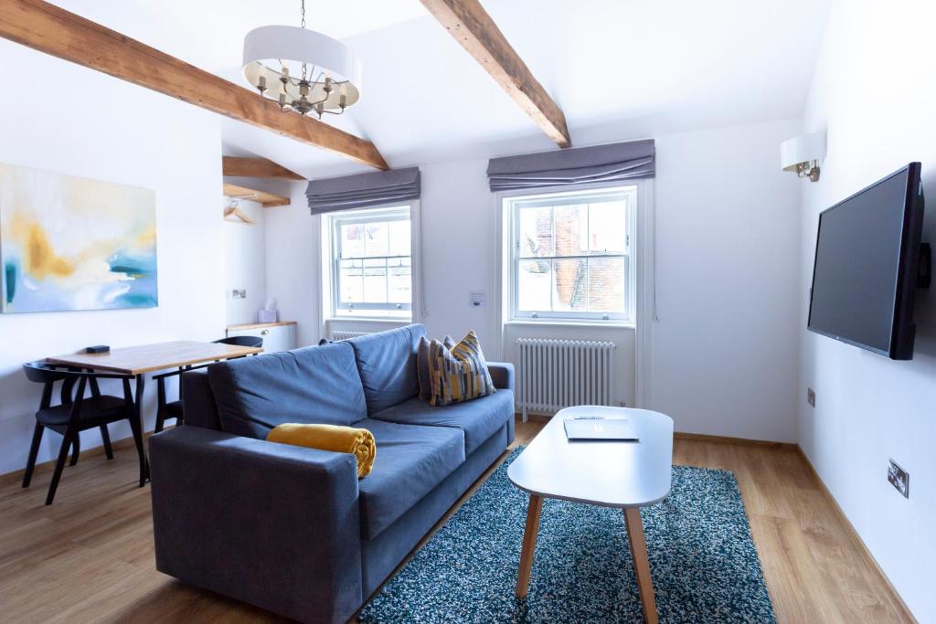 a living room with a blue couch and a table at Number 8 in Canterbury