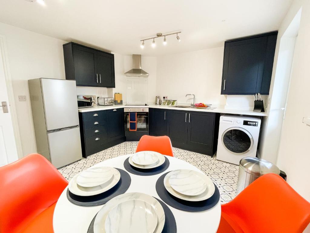 a kitchen with a white table and orange chairs at The New Found Lamb in Cleethorpes