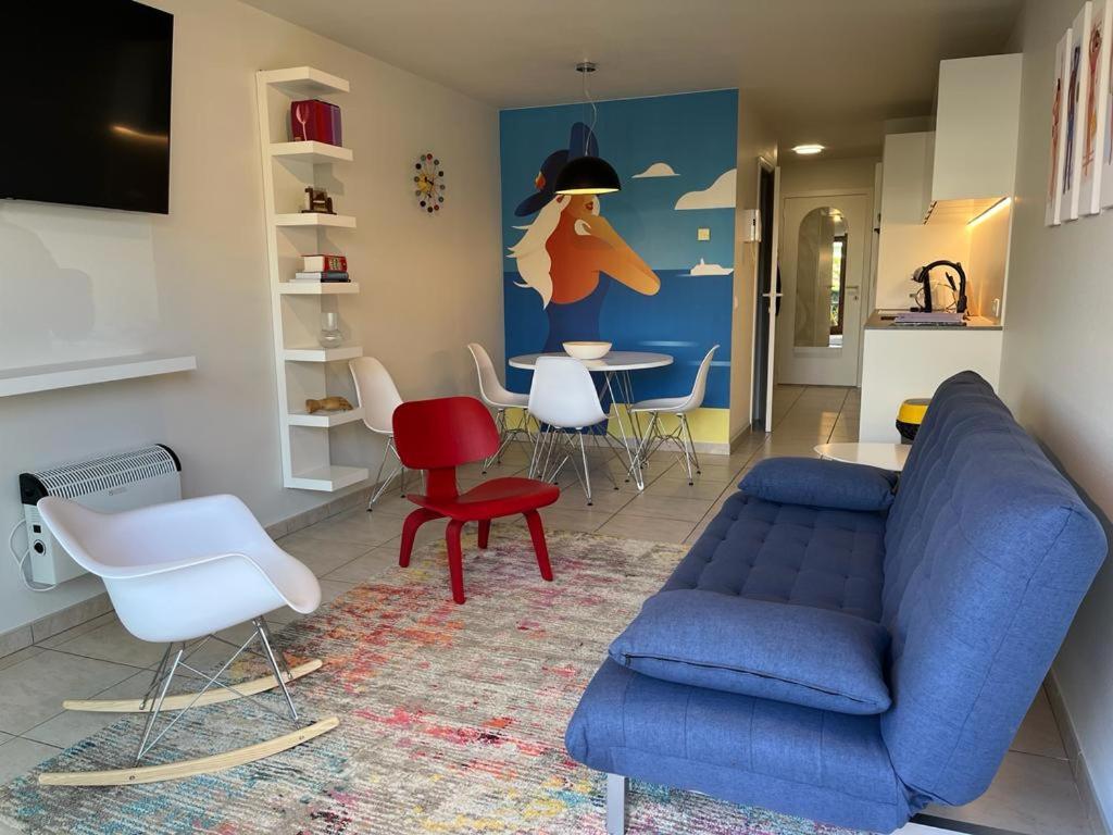 a living room with a blue couch and a table at Studio Blanchard in Koksijde