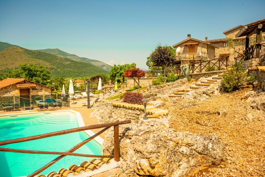 a swimming pool with stairs next to a house at Villa La Voce Del Vento in Pastena