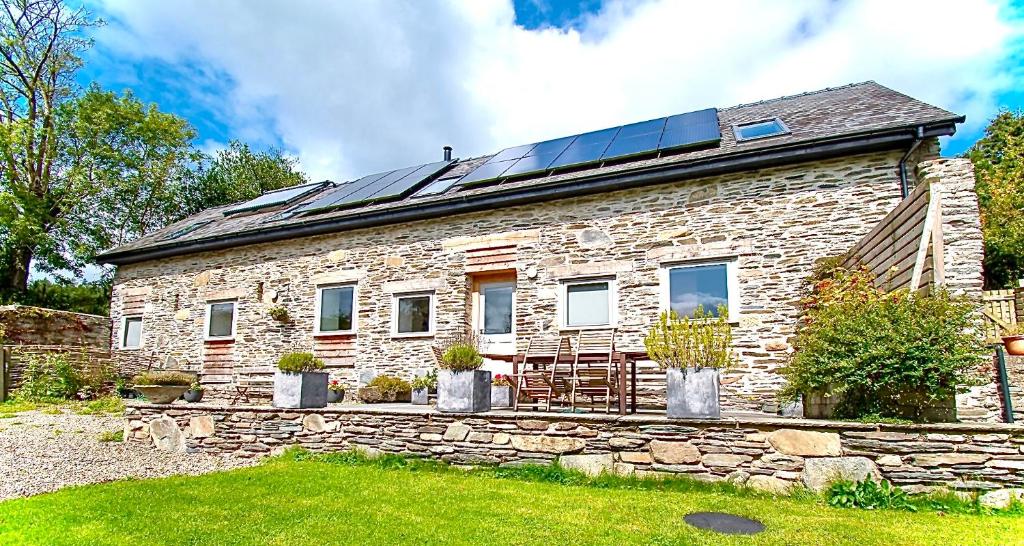 a stone house with solar panels on the roof at Cefn Ceiriog in Llangollen