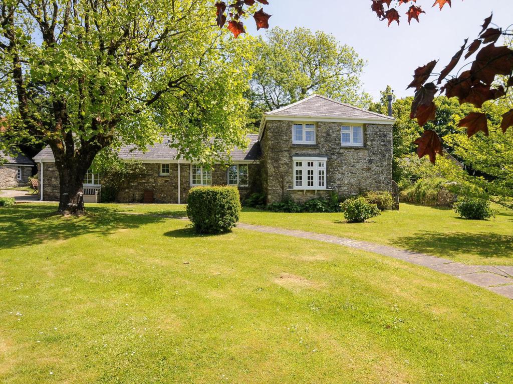 a large brick house with a grass yard at Byre in Camelford