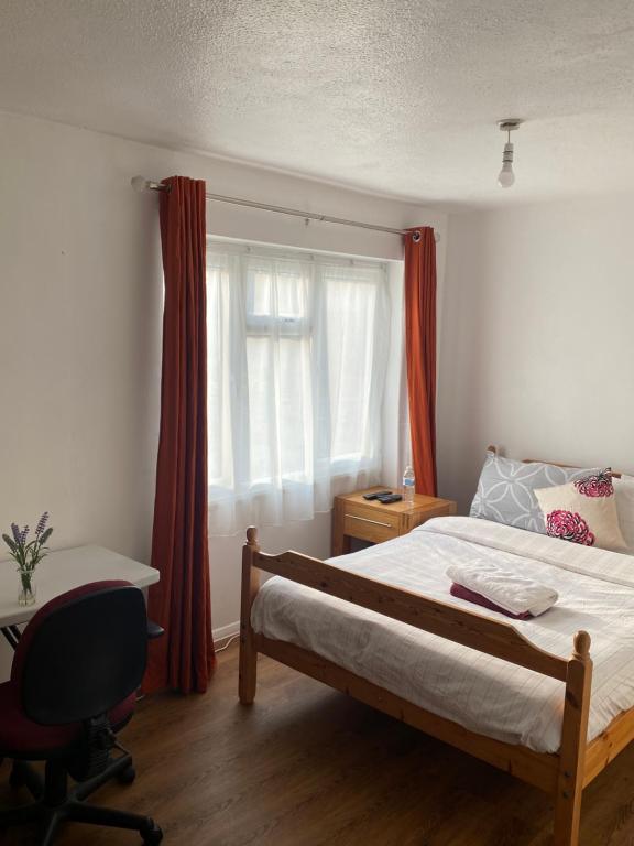 Schlafzimmer mit einem Bett, einem Schreibtisch und einem Fenster in der Unterkunft B Homestay in Maidstone